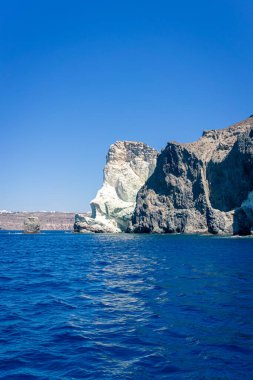 Mavi denizde mavi bir gökyüzüne karşı yüz şeklinde bir kaya. Akrotiri 'de, Santorini' de, Cyclades 'de, Yunanistan' da