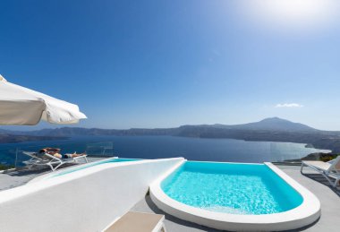 Santorini kalderasının üzerinde şezlong ve havuz. Akrotiri, Santorini Adası, Kiklad, Yunanistan, Avrupa. Lüks konsept