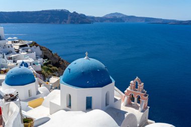Santorini 'nin tipik mavi kubbe kilisesi, deniz ve santorini kalderası manzarası.