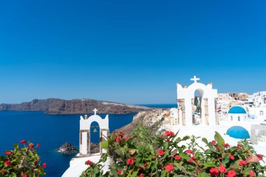 Oia kasabası ve ünlü beyaz kule çanları ve ortodoks kiliselerinin mavi kubbeleriyle Santorini Kalderası manzarası