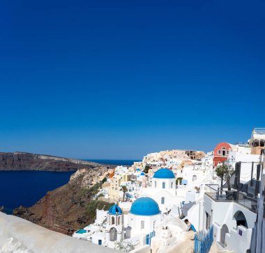 Santorini manzarası, tipik mavi kubbe kilisesi, eski badanalı evler ve kaldera