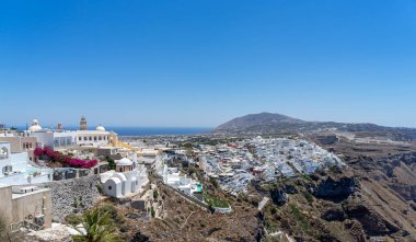 Santorini Adası 'ndaki Thira kasabasının panoramik manzarası. Güneşli bir günde eski beyazlatılmış evler ve tipik ortodoks kilisesi ve Yunanistan manzarası.