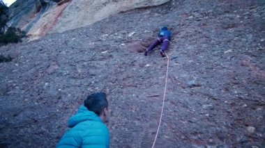 Arkadaşlar doğada kırmızı kayalara tırmanıyor. Yüksek kalite 4k görüntü