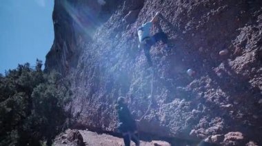 Arkadaşlar doğada kırmızı kayalara tırmanıyor. Yüksek kalite 4k görüntü