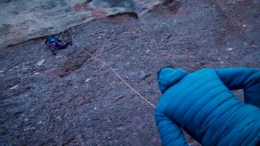 Arkadaşlar doğada kırmızı kayalara tırmanıyor. Yüksek kalite 4k görüntü