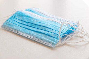 Mavi cerrahi maskeler, beyaz yüzeye yerleştirilmiş.