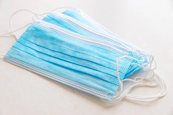 Mavi cerrahi maskeler, beyaz yüzeye yerleştirilmiş.