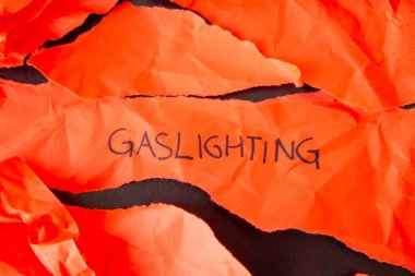 Word Gaslighting, written on torn red paper clipart