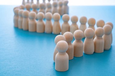 Concepts of order, discipline, conformity, waiting, and community, expressed with wooden figures arranged in a row.