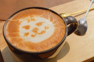 Kedi yüzlü latte sanat kahvesi ahşap masada, şirin Neko latte sanat kahvesi, hayvan latte sanatı.