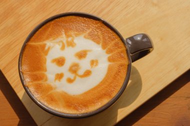Kedi yüzlü latte sanat kahvesi ahşap masada, şirin Neko latte sanat kahvesi, hayvan latte sanatı.