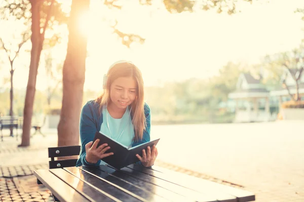 Mujer Sonriente Anteojos Leyendo Libro Escuchando Música Con Auriculares Parque Fotos De Stock Sin Royalties Gratis