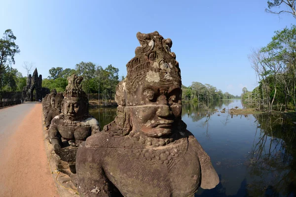 アンコール トム都市アンコール カンボジアの西のシェムリ アップ市近くの寺市に南門橋でカンボジア シェムリ アップ 2014 石の顔 — ストック写真