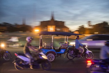 Kamboçya, Phnom Penh - 16 Aralık 2017: Tuk Tuk taksi Sisowath Quay adlı Tonle Sap nehir, Kraliyet Sarayı önünde 