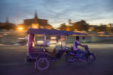 Kamboçya, Phnom Penh - 16 Aralık 2017: Tuk Tuk taksi Sisowath Quay adlı Tonle Sap nehir, Kraliyet Sarayı önünde 