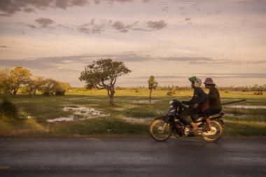 Kamboçya, Kampong Thom - Kasım, 2017: Sürücü: Kampong Thom, Cambodia şehir merkezine yakın bir yol, pirinç tarlaları ile motosiklet üzerinde