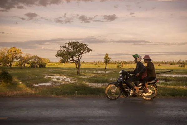 Kamboçya, Kampong Thom - Kasım, 2017: Sürücü: Kampong Thom, Cambodia şehir merkezine yakın bir yol, pirinç tarlaları ile motosiklet üzerinde