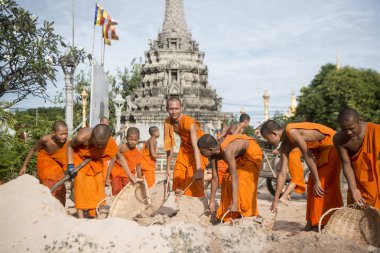 CAMBODIA, KAMPONG THOM - NOVEMBER, 2017: Young monks wort at a construction for a new building at the Wat Kampong Thom Temple in the city of Kampong Thom of Cambodia clipart