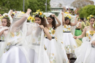 Funchal Şehir Adası Madeira Portekiz Atlantik Okyanusu Festa da Flor veya bahar çiçek Festivali renkli elbise makyaj ile kısa rainshower tarafından giymiş kadın kapak. Madeira, Funchal, Nisan, 2018