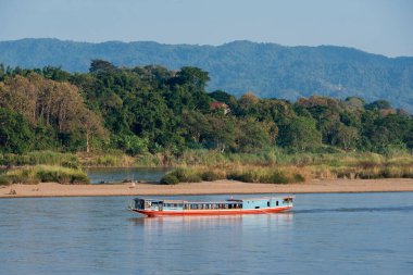 Tayland 'ın Chiang Raii şehrindeki Chiang Khong kasabasındaki Mekong Nehri' ndeki peyzajda bir mekong nehir tur botu. Tayland, Chiang Khong, Kasım 2019