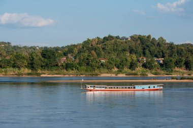 Tayland 'ın Chiang Raii şehrindeki Chiang Khong kasabasındaki Mekong Nehri' ndeki peyzajda bir mekong nehir tur botu. Tayland, Chiang Khong, Kasım 2019