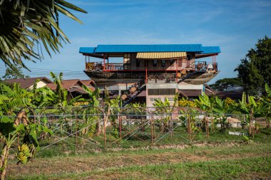 Tayland 'ın Ubon Ratchathani ilindeki Buda Sathan Ratchathani Asoke Köyü' nde yaşayan bir tekne. Tayland, Khemmarat, 27 Kasım 2023