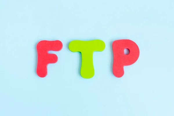 File Transfer Protocol. Word ftp on blue background. Flat lay, top view.