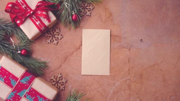愉快的圣诞节概念与松树树枝 礼品盒和手把空白卡片在桌子上 — 图库视频影像