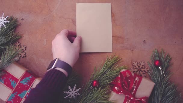 愉快的圣诞节概念与松树树枝 礼品盒和手把空白卡片在桌子上 — 图库视频影像
