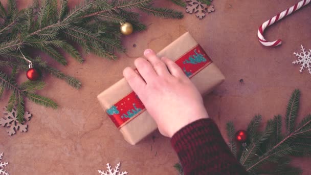 Menschliche Hand Legt Weihnachtsgeschenk Auf Den Tisch — Stockvideo