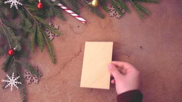 松の木の枝 テーブルに空白カードを置く手が幸せのクリスマス コンセプト — ストック動画