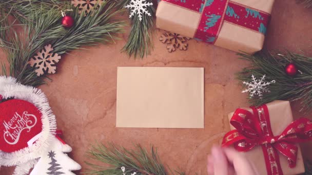松の木の枝 ギフト ボックス テーブルに空白カードを入れて手で幸せなクリスマスのコンセプト — ストック動画