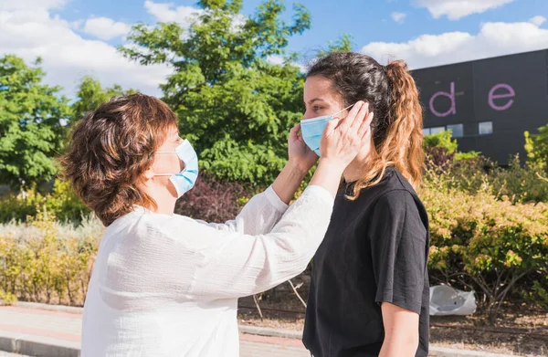 Yeni normal. Anne ve kızı kendilerini koronavirüse karşı koruyorlar. Anne kızını salgından korumak için maske takıyor. Coronavirus cihazları. Güvenlik ve salgın konsepti