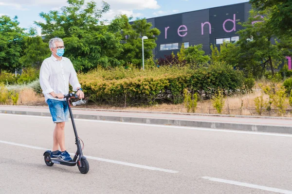 New normal. Man girl with a mask using an electric scooter. Man using electric and ecological transport Safety and pandemic concept. Coronavirus devices. Social distance. Coronavirus.