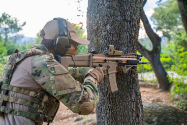 Amerikan Deniz Piyadesi ve saldırı tüfeği. Saldırı tüfeğiyle hafif bir nişancı. Hava yumuşaklığını oynayarak eğlenen adam. Denizci atış talimi yapıyor. Savaş için silahlar. Asker. Denizci. Yumuşak.
