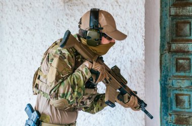 Amerikan Deniz Piyadesi ve saldırı tüfeği. Çoklu kamuflaj. Amerikan ordusu özel bir operasyonda. Havalı oyuncu. Denizci atış talimi yapıyor. Savaş için silahlar. Asker. Denizci. Yumuşak.