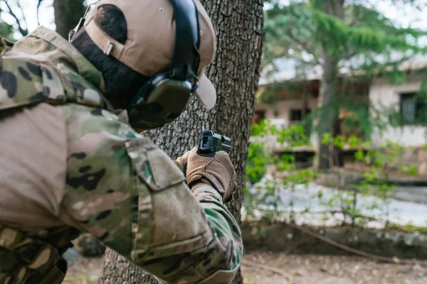 Soldier pointing his gun. USP gun. Airsoft player. Multicam camouflage. Mlitar in the woods. United States Navy. Airsoft guns. United States Navy. Soldier. Marine. Cutting weapon range. Airsoft.