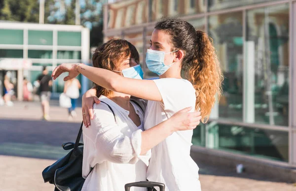 Yeni normal. Anne ve kızı yeni normallik içinde birbirlerini kucaklıyorlar. Anne ve kızı birbirlerine maskeyle sarılıyorlar. Sevgi. Aile
