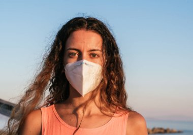 Sahilde koronavirüs maskesi takıyordu. Halka açık yerlerde tıbbi maske takmak. Coronavirus karantinası. Covid-19 salgınında seyahat ve tatil.