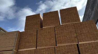 Büyük ahşap desteler titizlikle bir kereste deposunun arka planına ve kısmen bulutlu gökyüzüne uzanan bir geometrik desen oluşturan bir kereste deposuna yerleştirilmiştir.