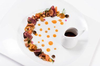 Bir tabak et, sebze ve sos.