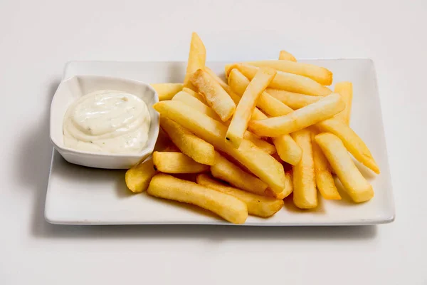 Beyaz arka planda bir tabak patates kızartması.