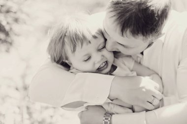 Babalık kavramı. Babam gülümsedi ve bebekle oynadı. Küçük bir çocukla oyunlar. İlgili ebeveynler çocuklarıyla oynarlar. Mutlu bir çocukluk. Babalar Günü.