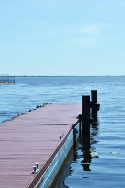 Tahta iskele suya iniyor. Deniz kıyısındaki ahşap iskele manzaralı.