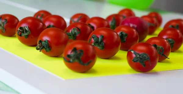 Taze bir kırmızı kiraz domatesi ve bulanık domates arka planına odaklan. Sebze sağlıklı konsept