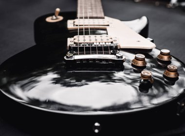 Siyah ve beyaz elektro gitar. Yakın plan müzik aleti. Gitarın parçalarıyla şık bir hayat. Akbaba, güverte ve ipler. Bas enstrümanı ince ayarlıyor.