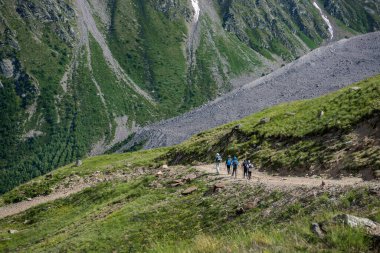 Bir grup insan yazın dağlarda yürüyüş yapıyor. Seyahat ve turizm. Aktif bir yaşam tarzı, sağlıklı bir zihin, spor.