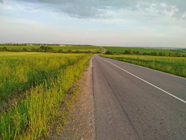 Gün batımında tepelerin arasında boş bir yol. Yalnız seyahat.