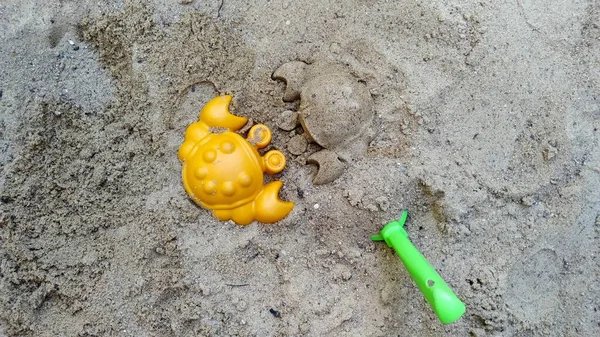 オレンジ色のカニと砂で作られたカニの像です — ストック写真