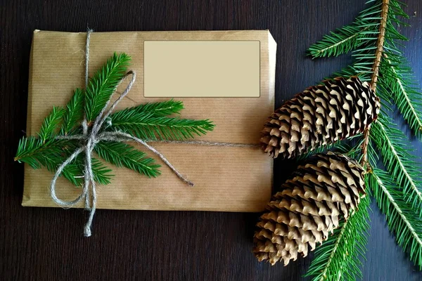 크리스마스 선물이 수공예 종이로 포장되어 있고 전나무 가지들이 모조품으로 장식되어 있다 — 스톡 사진